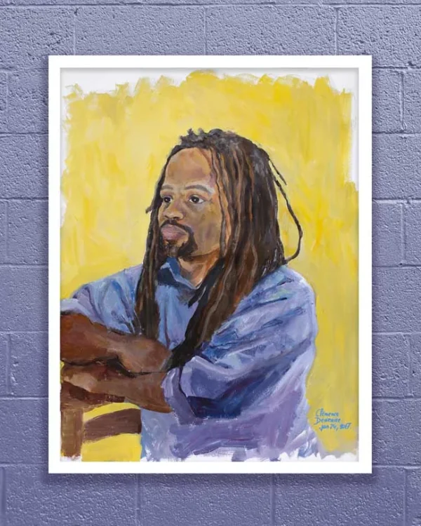 Portrait de Ron : homme aux dreadlocks, bras croisés, chemise bleue, sur fond jaune, dans un cadre blanc